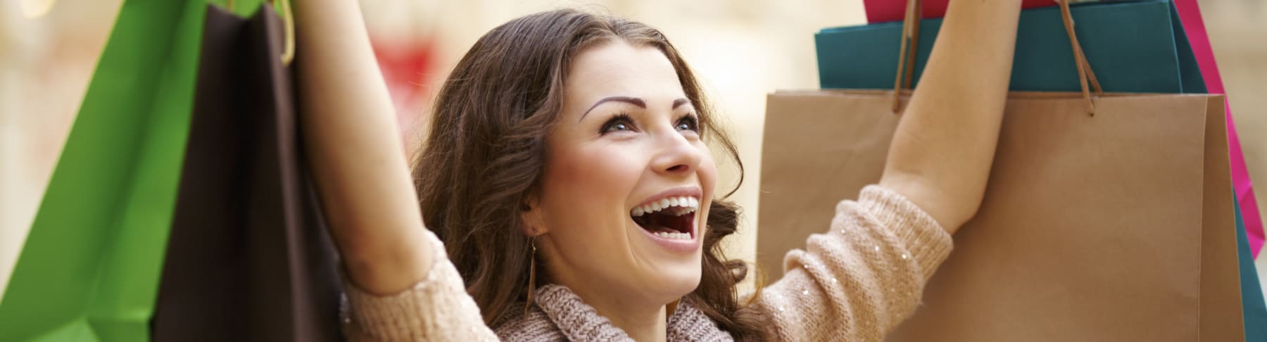 Happy woman holds shopping bag in air.