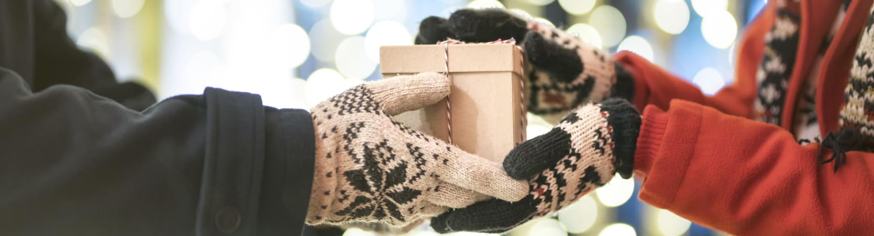 Gloved hands exchanging gifts.