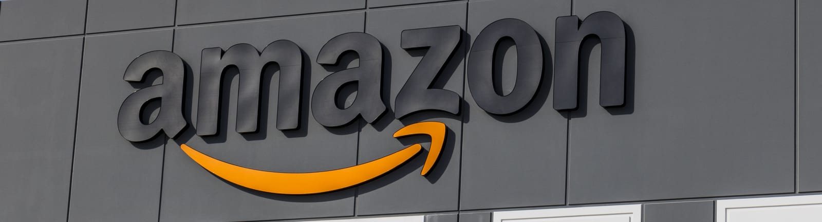 Amazon sign is shown on exterior of warehouse.