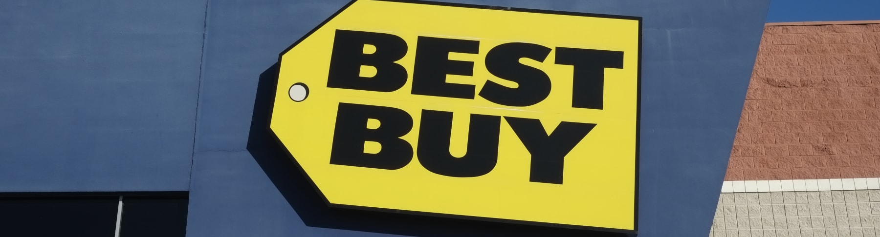 Yellow Best Buy sign hangs on store's exterior.
