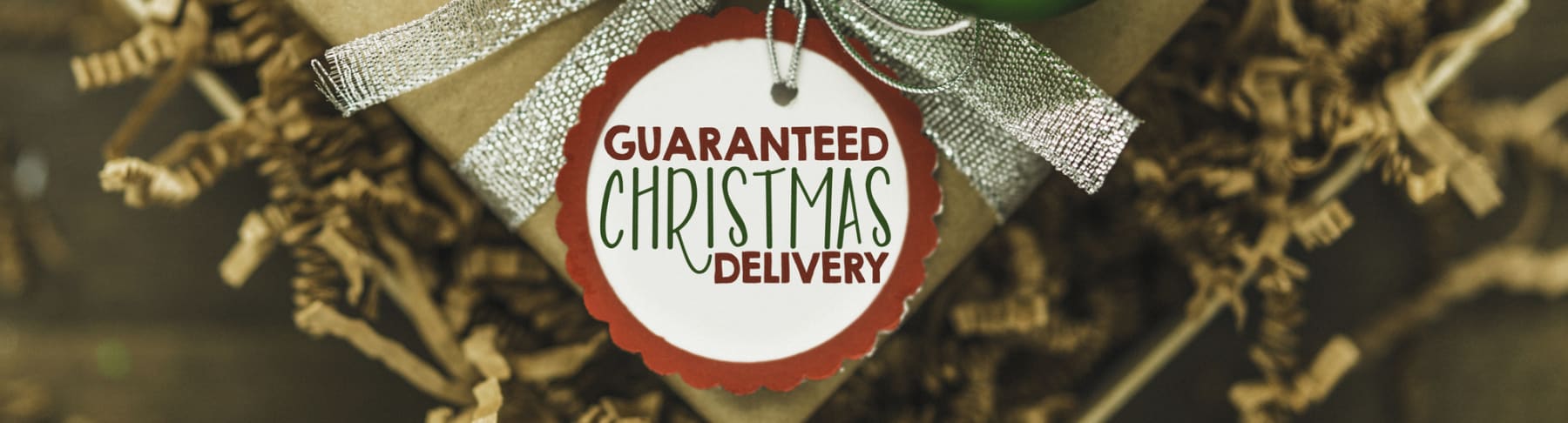 Gift box with Guaranteed Christmas Delivery tag attached.