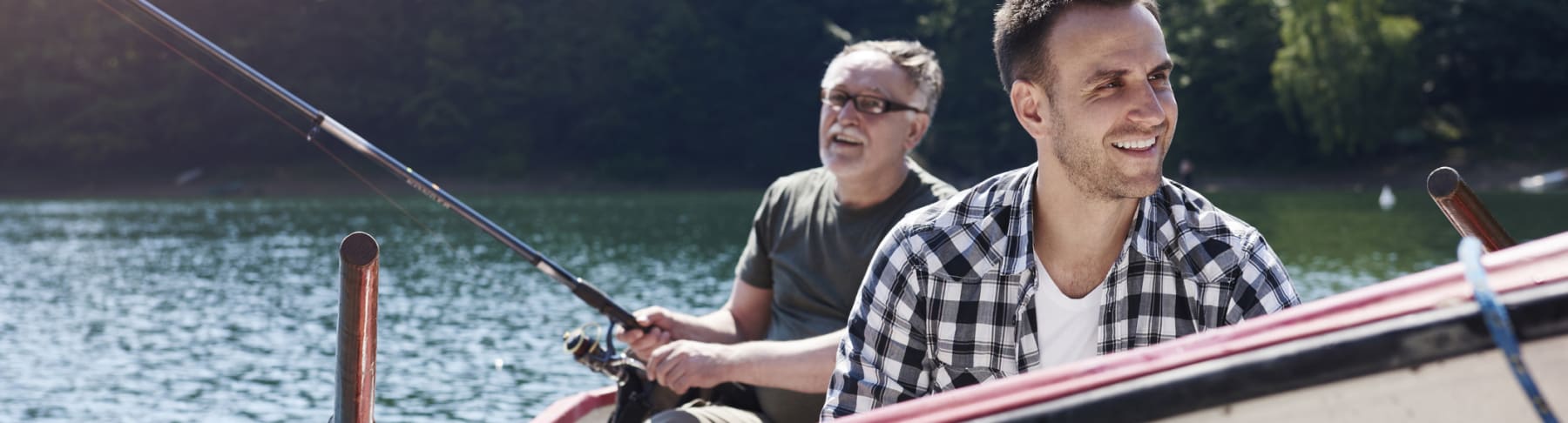 Father and son fish from a boat.