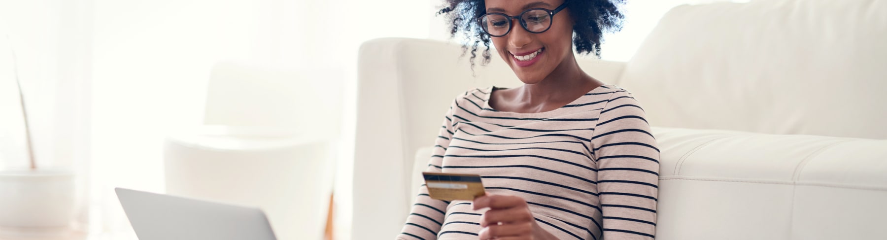 Black woman shops online with credit card.