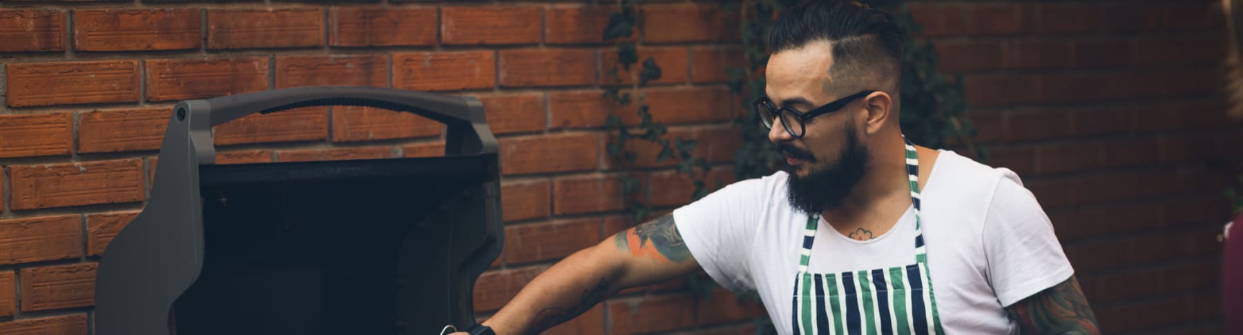 Man cooks hamburgers on grill.