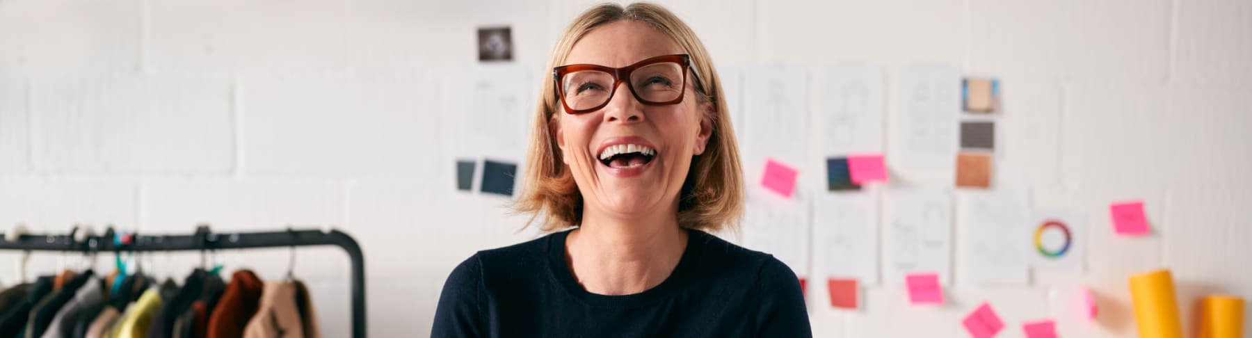 Mature businesswoman smiles while using phone.