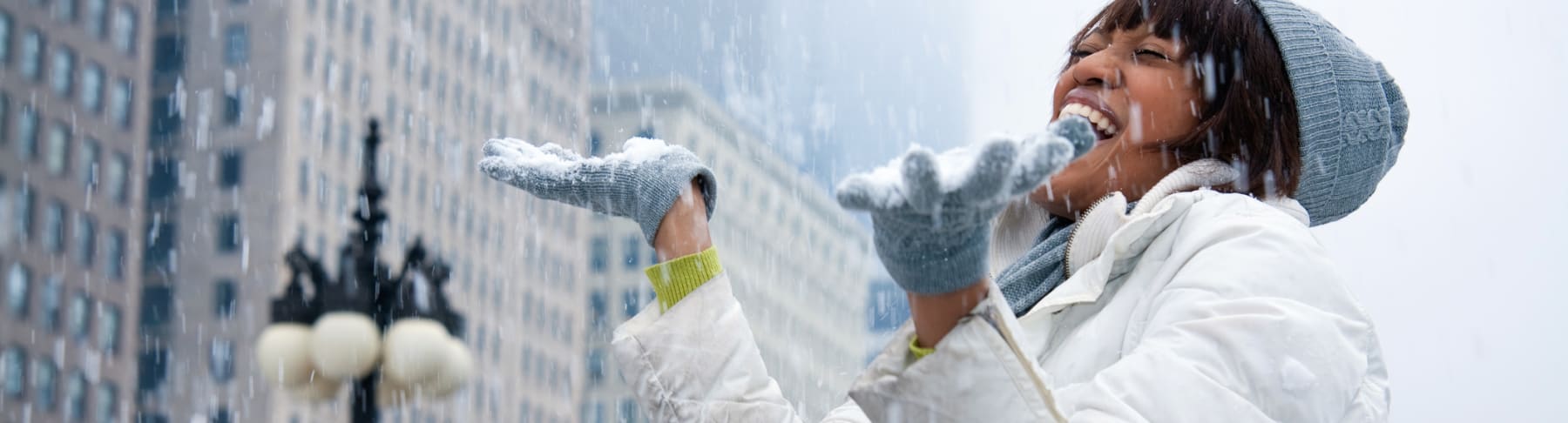 Woman catches snow in the city.