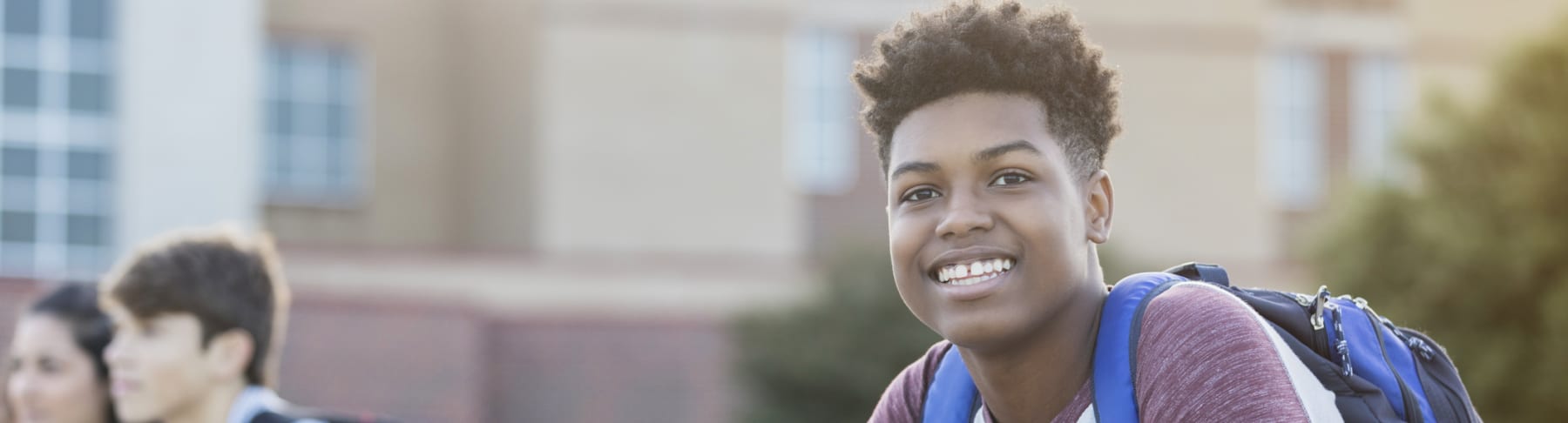 Student wears a backpack outside of school.