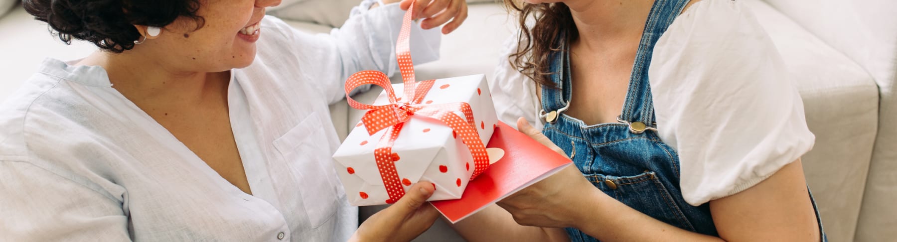 Woman opens gift from girlfriend.