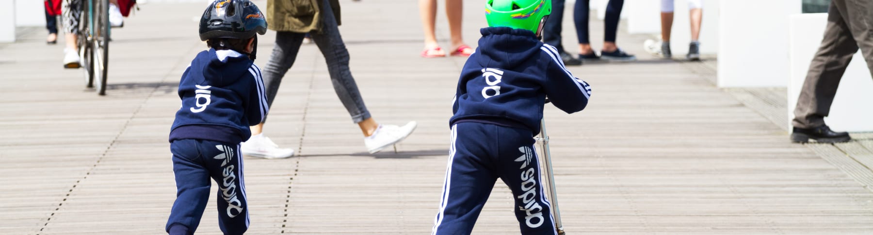kids wear adidas while riding scooters