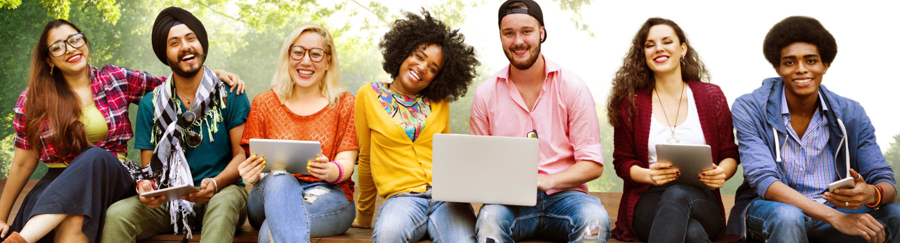 College students sit in a row on bench.