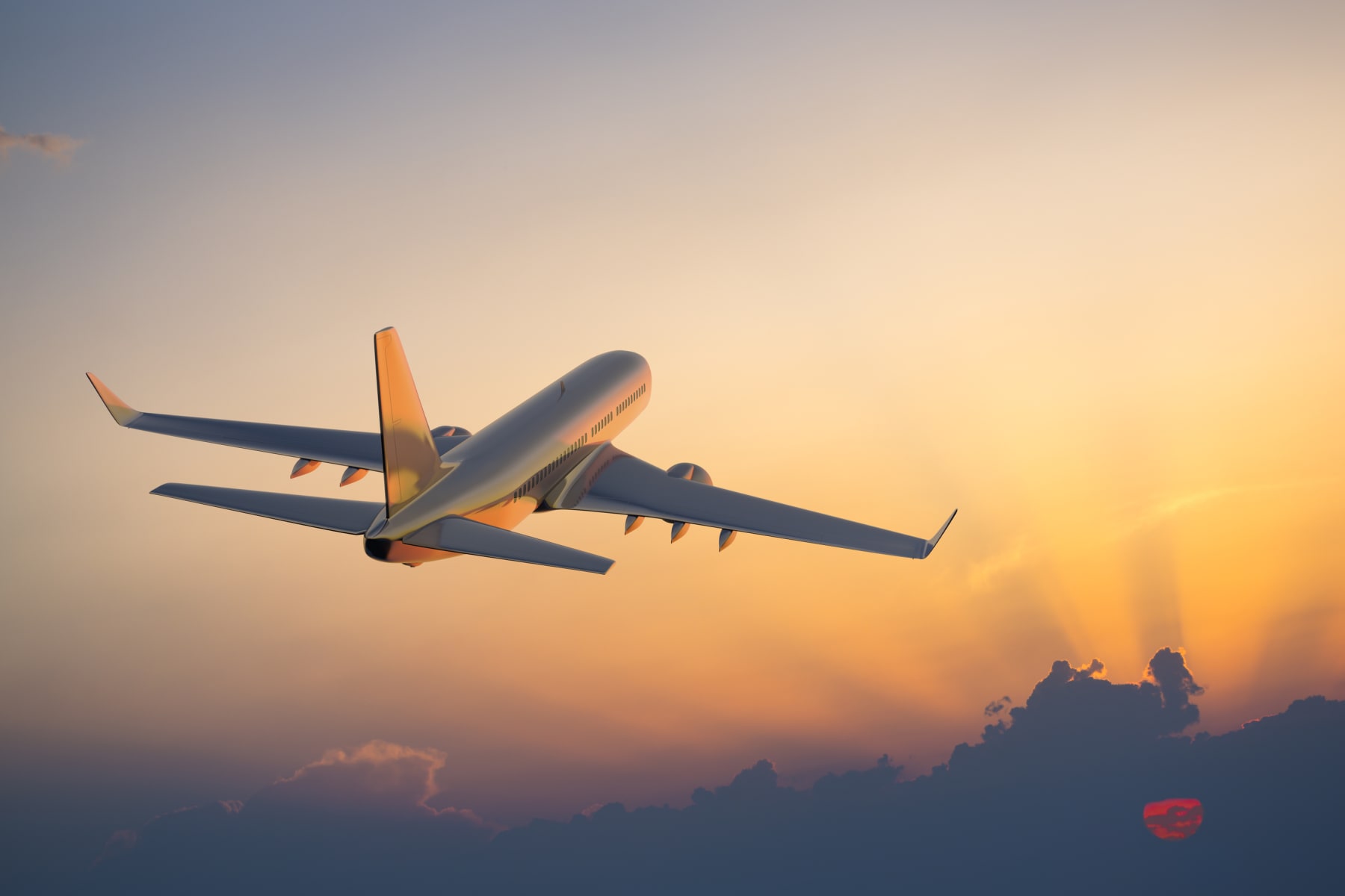 Plane flying in sunset sky.