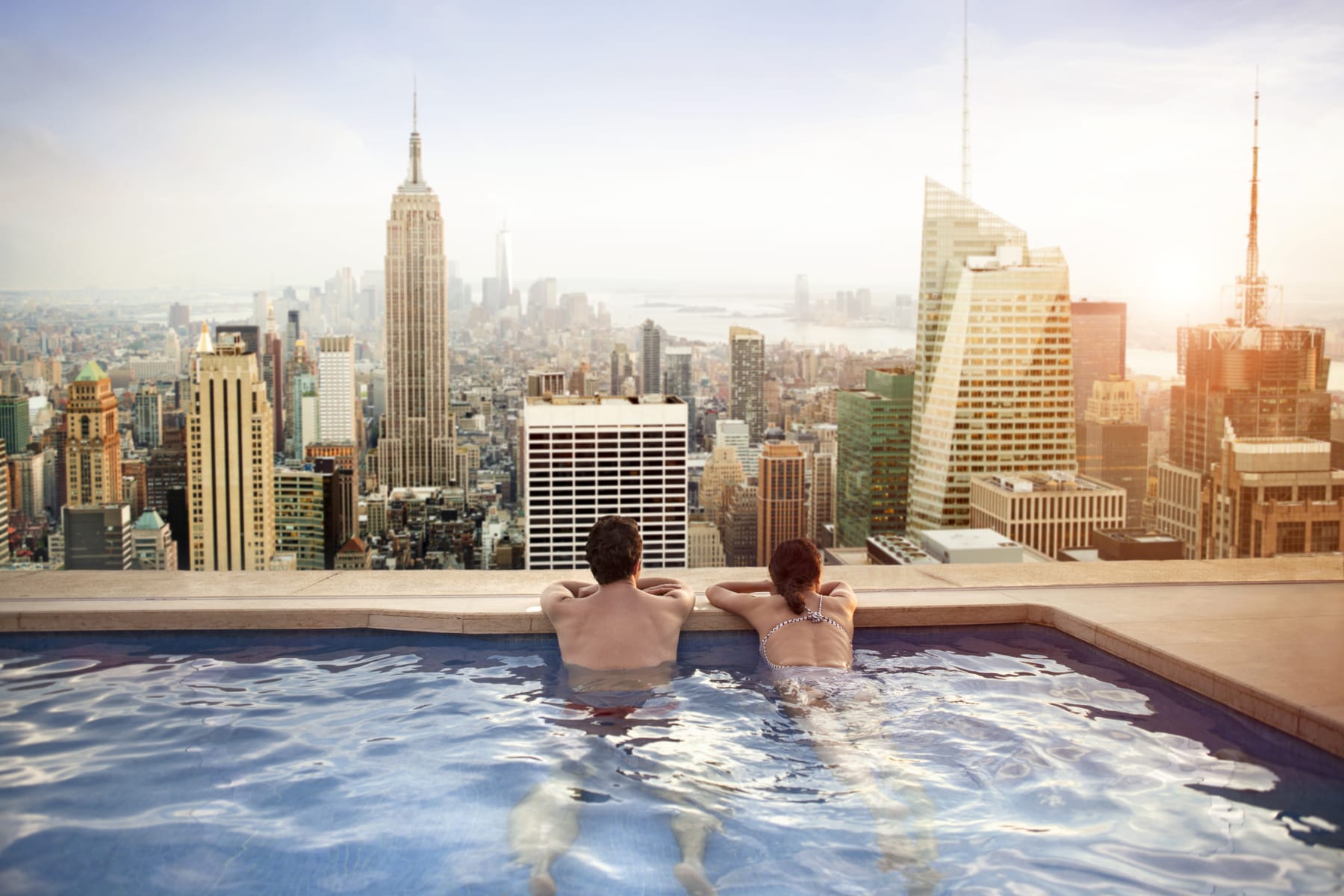 couple relaxes in hotel rooftop pool