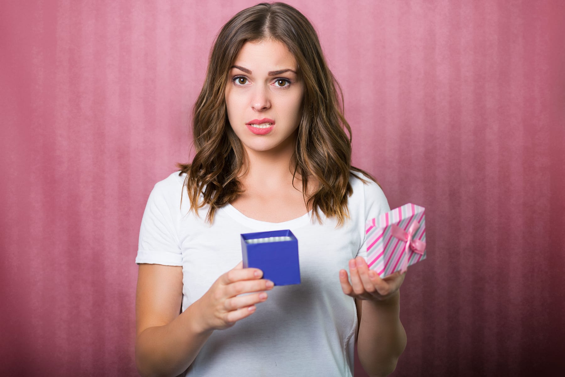 Woman disappointed with gift she's holding.