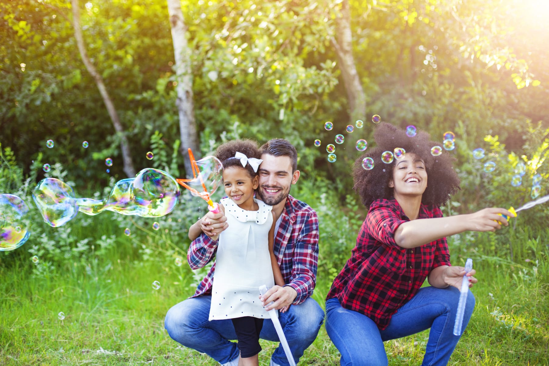 A family plays with bubbles outside during a beautiful spring day.