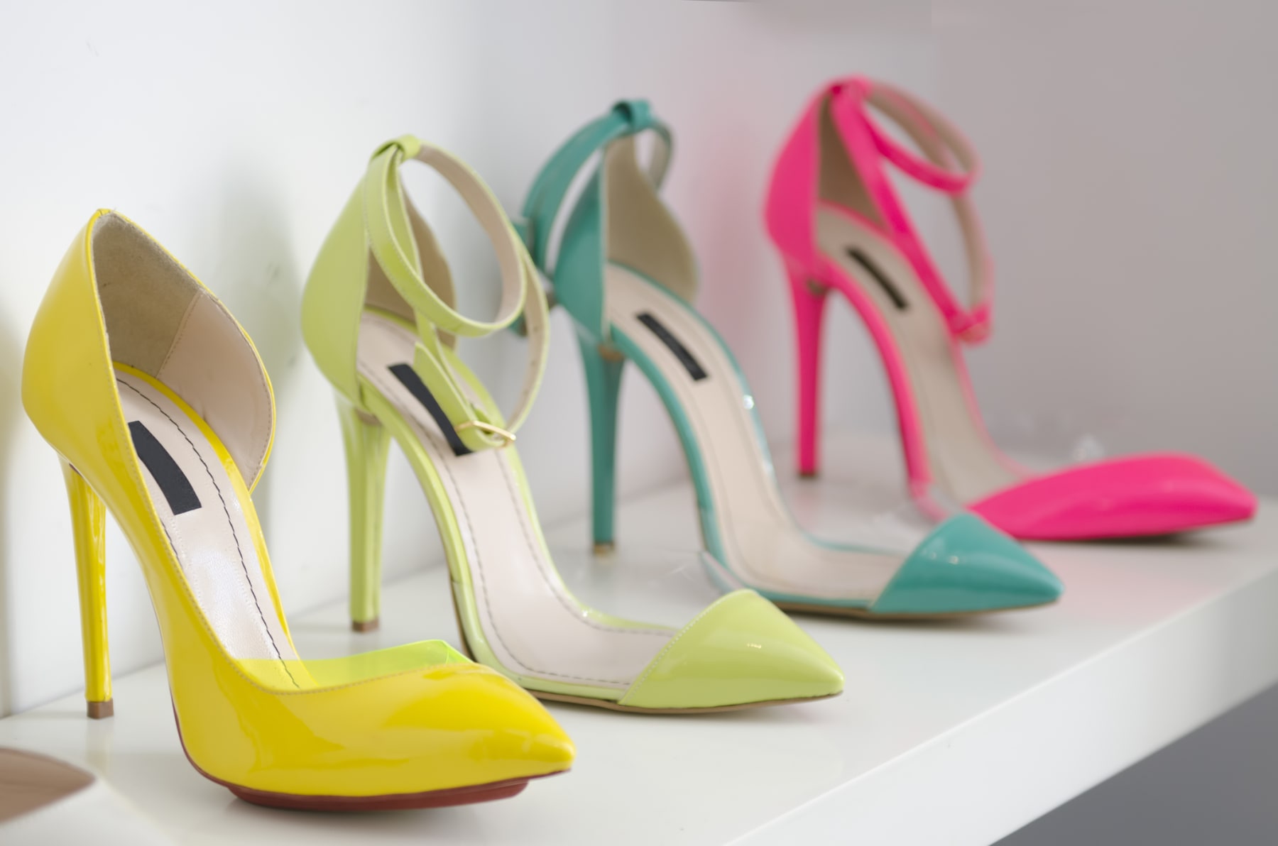 Four high-heeled women's shoes are displayed in a row.