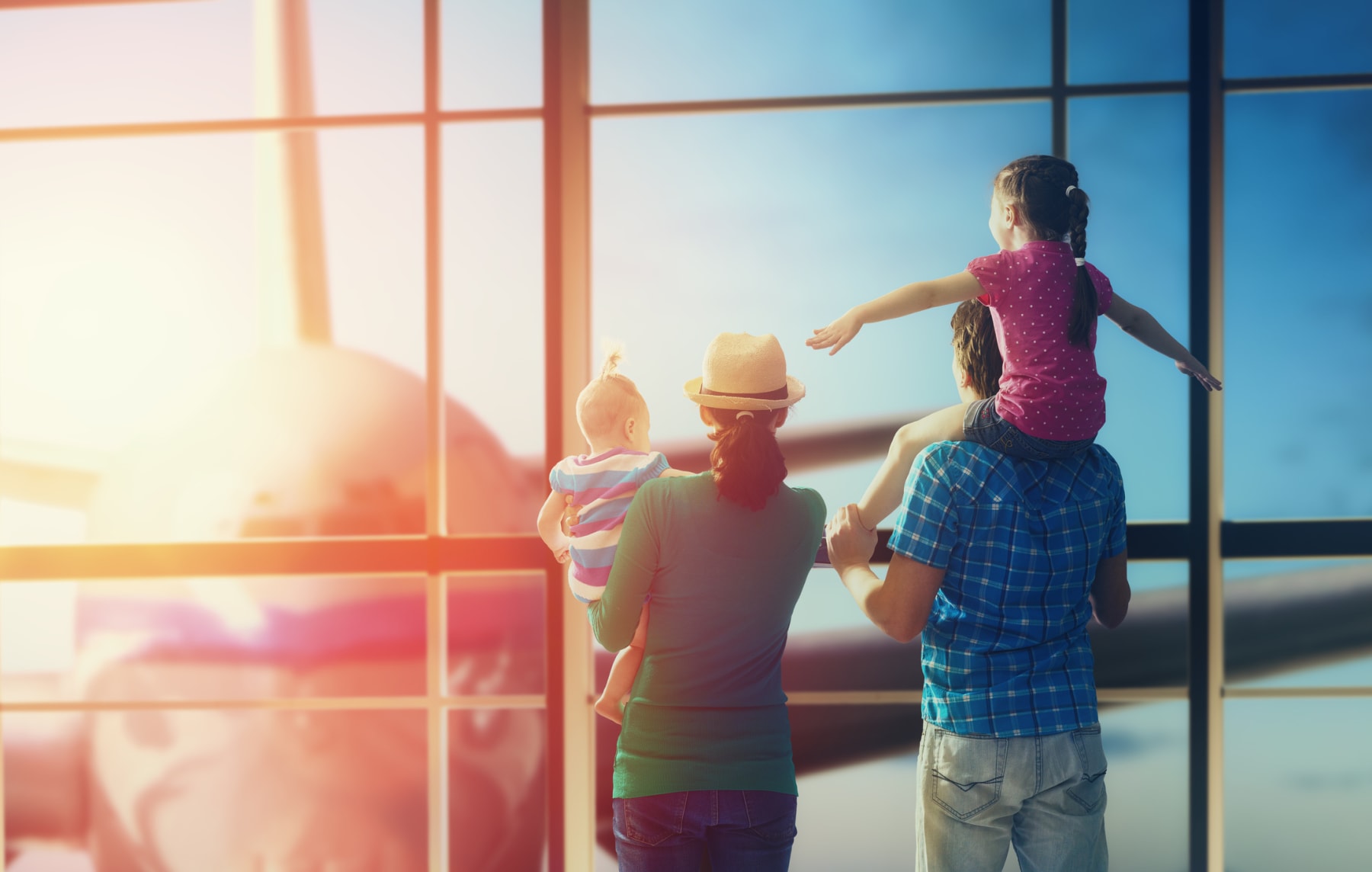 Family in airport looks at plane.
