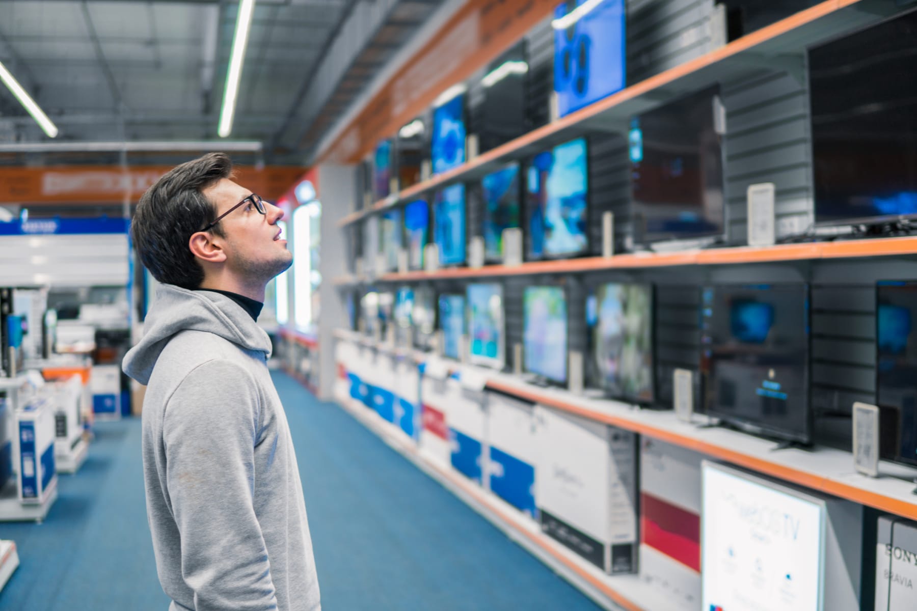 Man shopping for TVs.