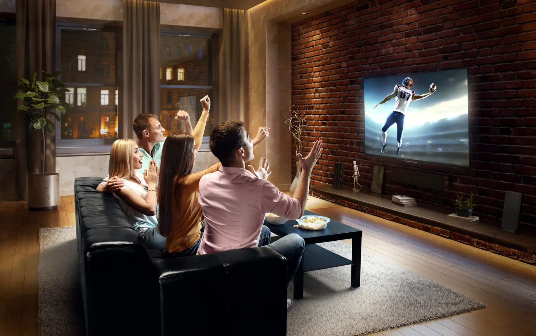 Couples cheer while watching football on TV.