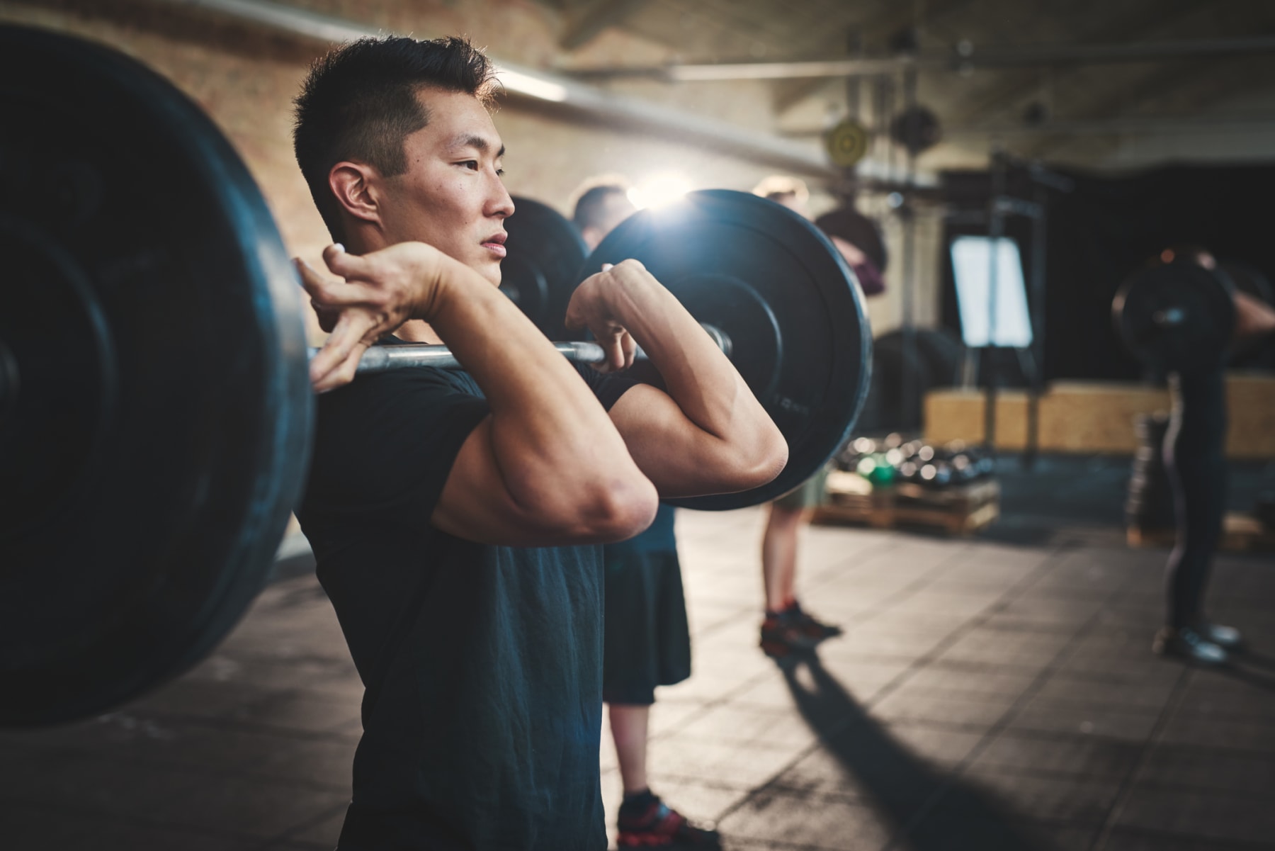 Man lifts weights in gym.