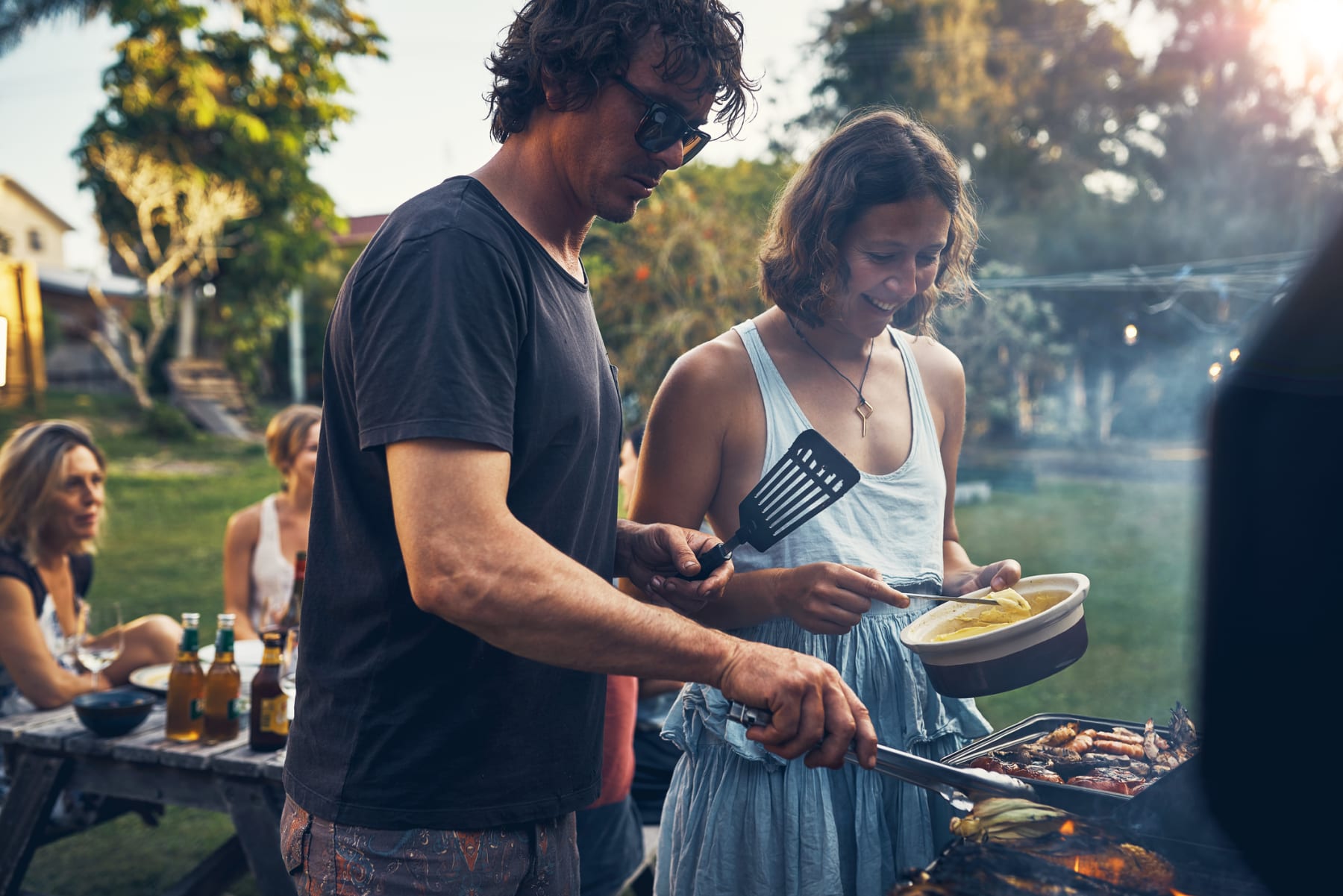 man and woman grilling food in the backyard