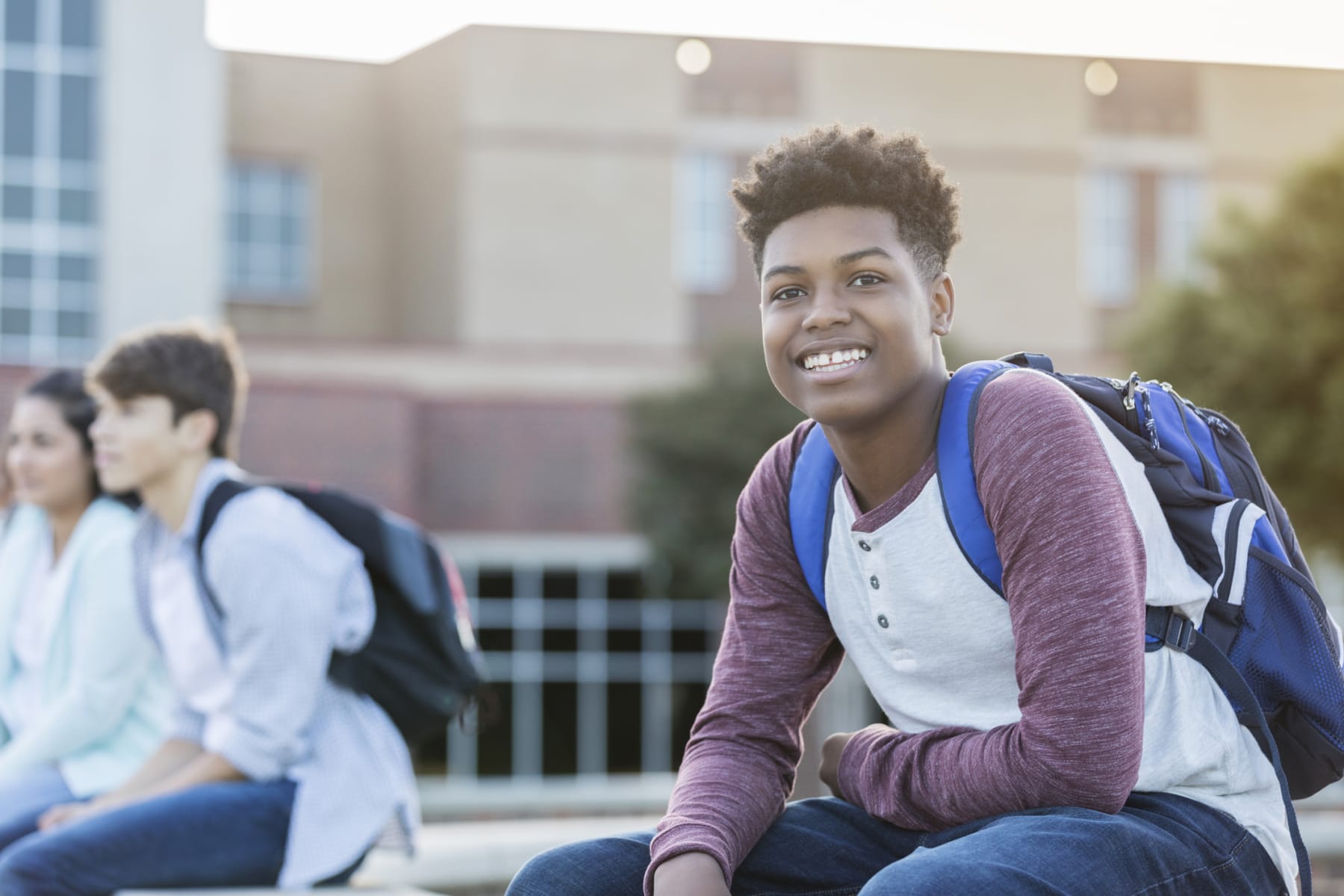 Student wears backpack outside of school.