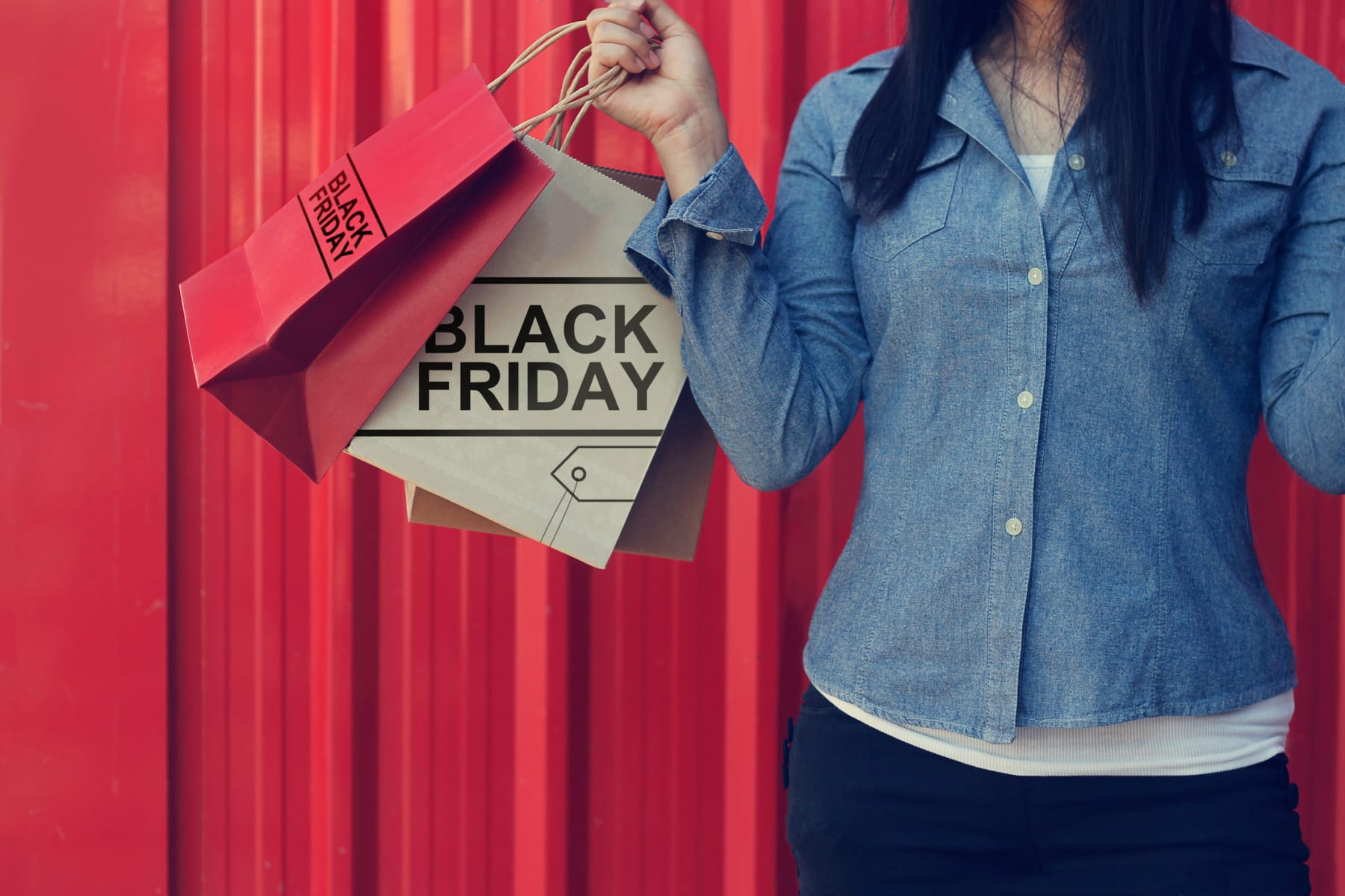 Woman holds Black Friday shopping bags.