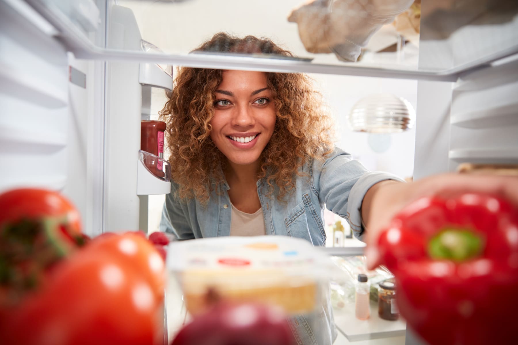 woman puts food into fridge