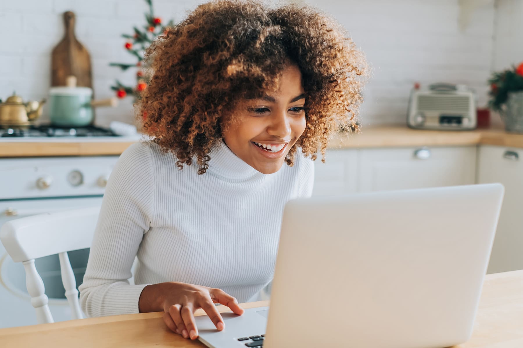 Young woman leans toward laptop while online shopping.