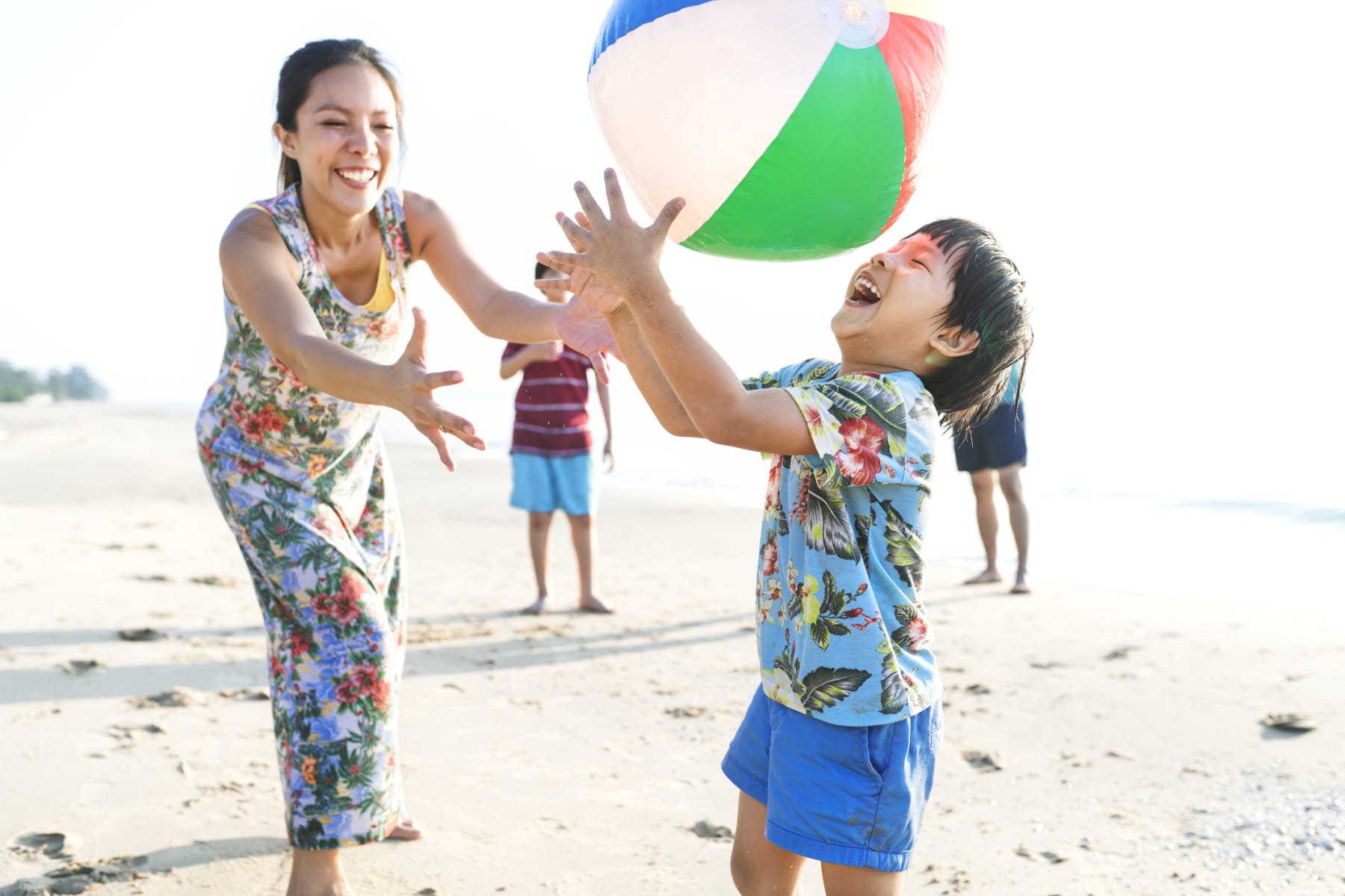 Family playing with beach ball on the beach.