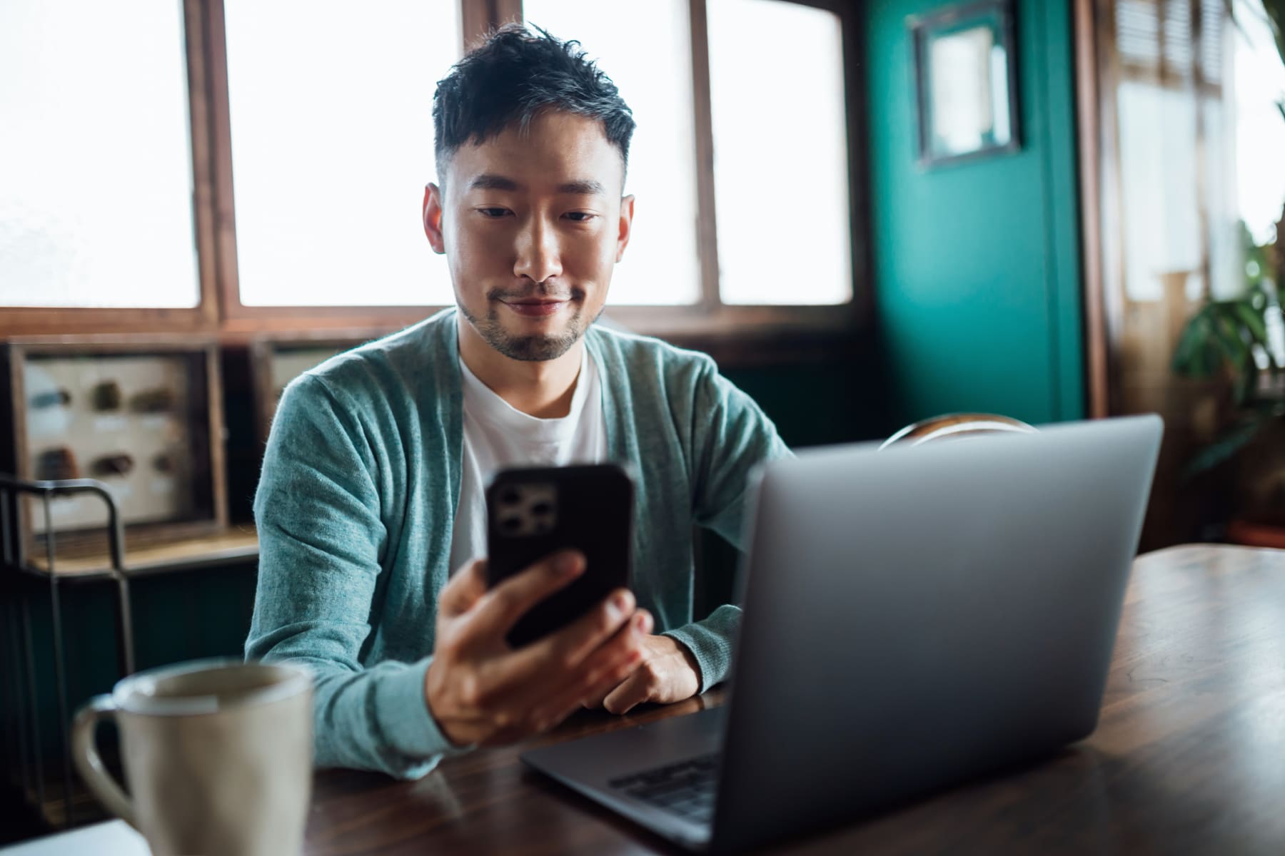 Person working on laptop and phone.