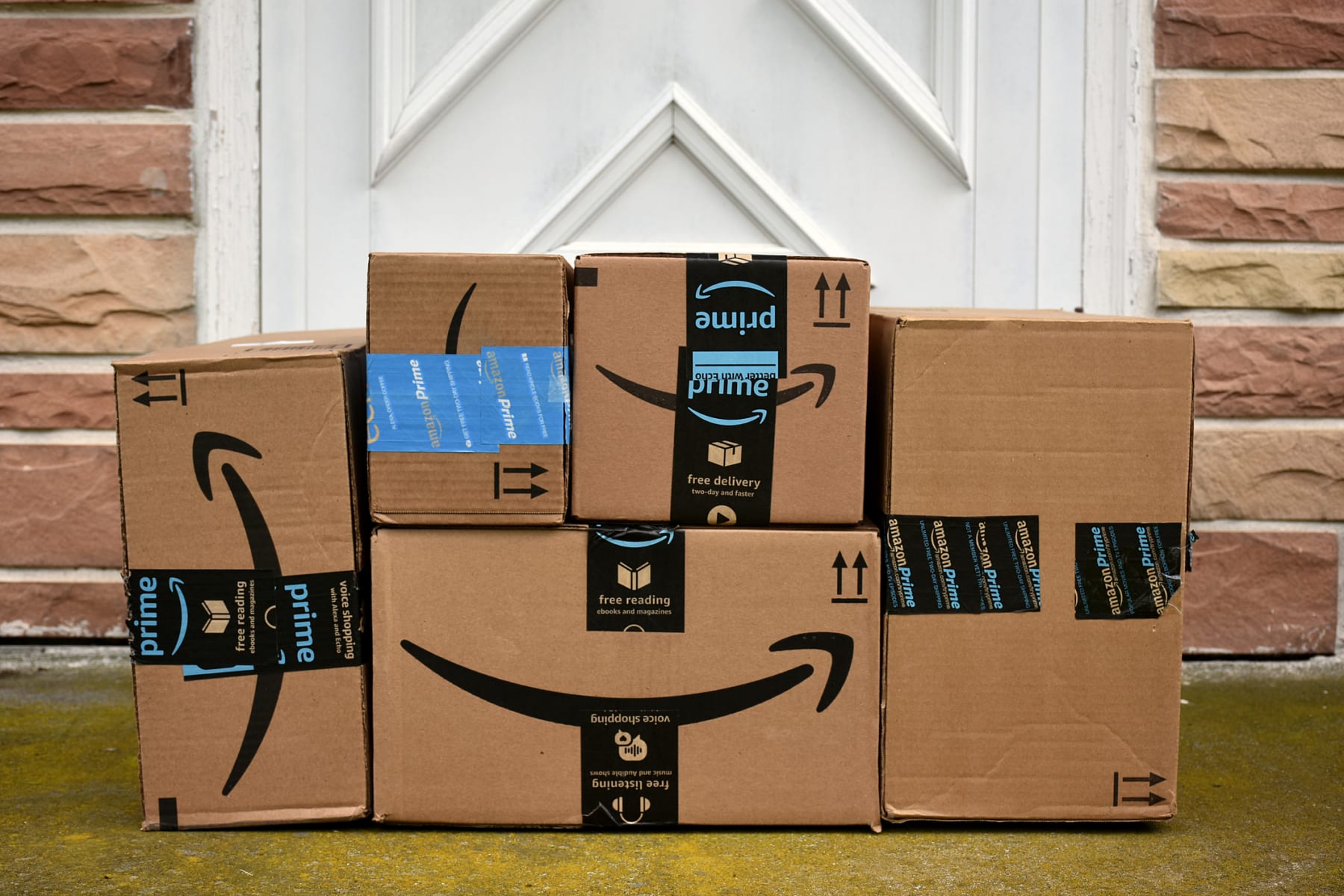 Amazon Prime packages arranged in front of door.