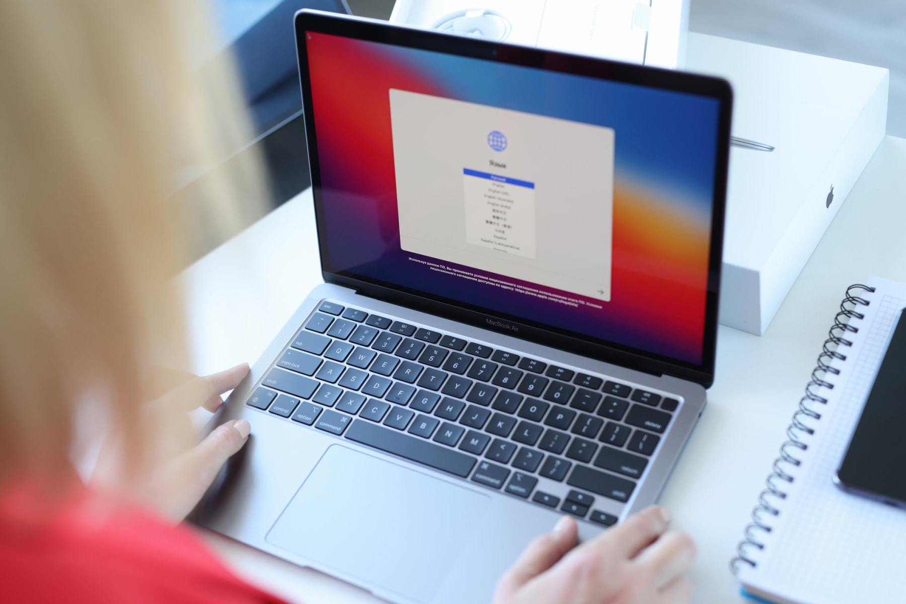 Woman choosing language on new laptop Apple MacBook air closeup