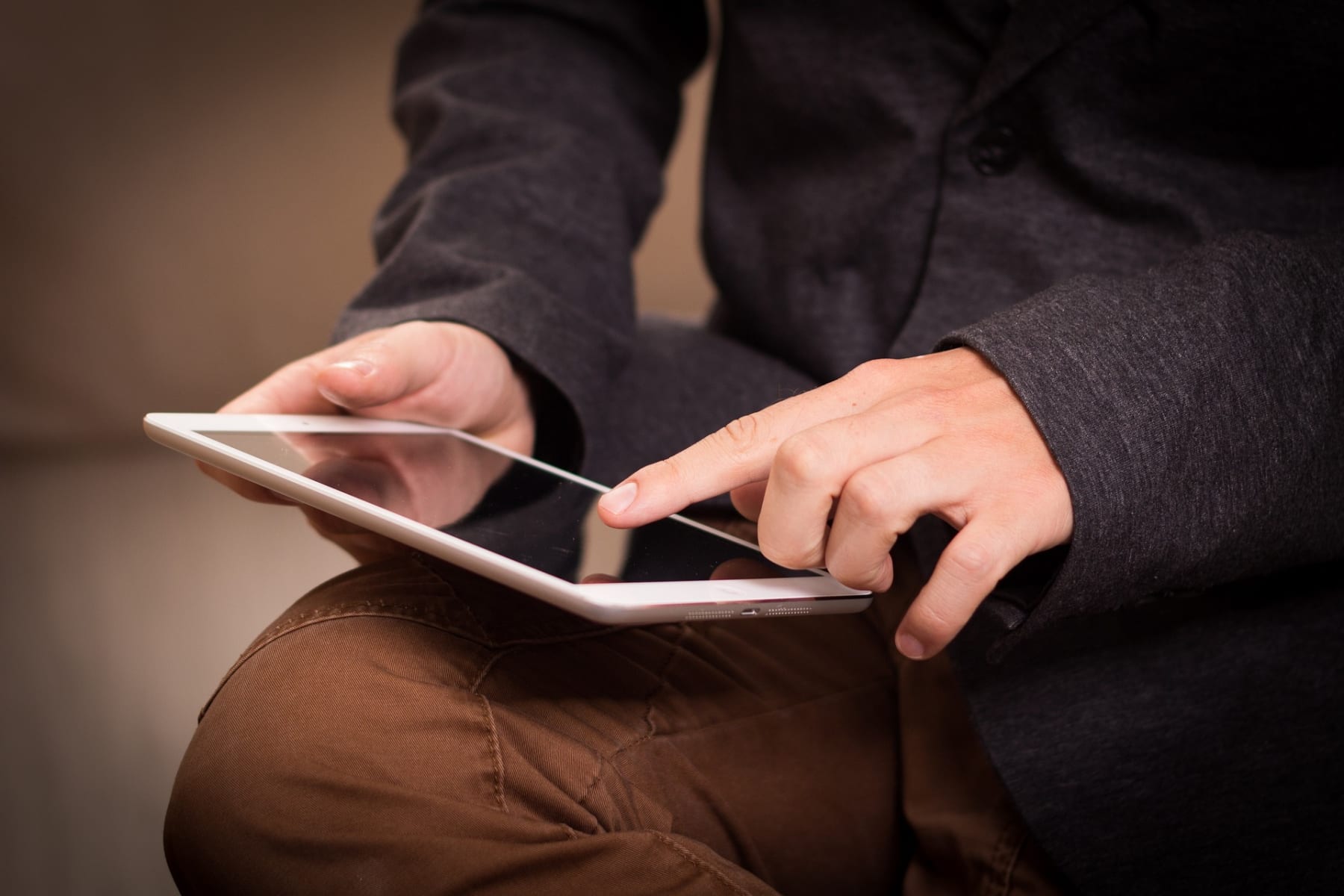 A person using an iPad with one finger on the screen.
