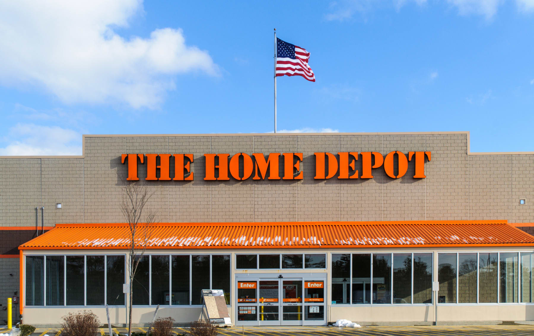 A Home Depot storefront with an American flag flying over it