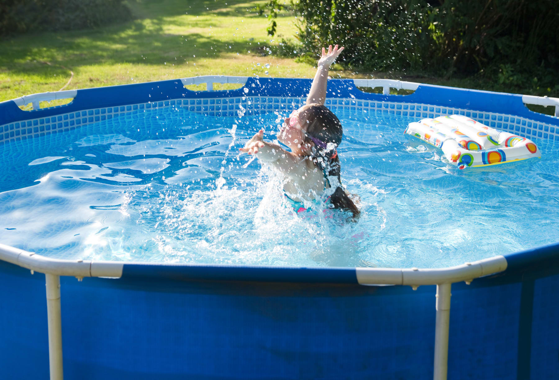 Child plays in above-ground swimming pool.