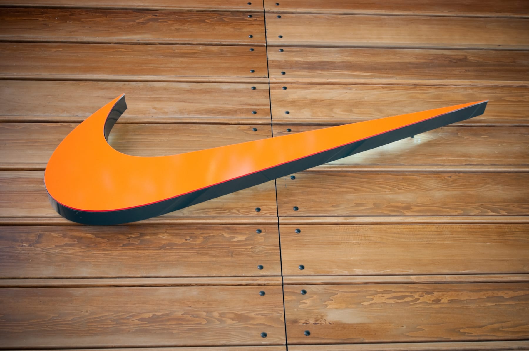 Nike Swoosh logo hangs on a wall.