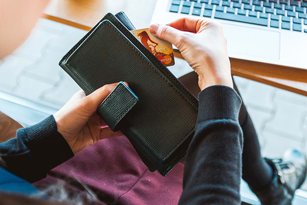 Shopper removing credit card from their wallet for online shopping