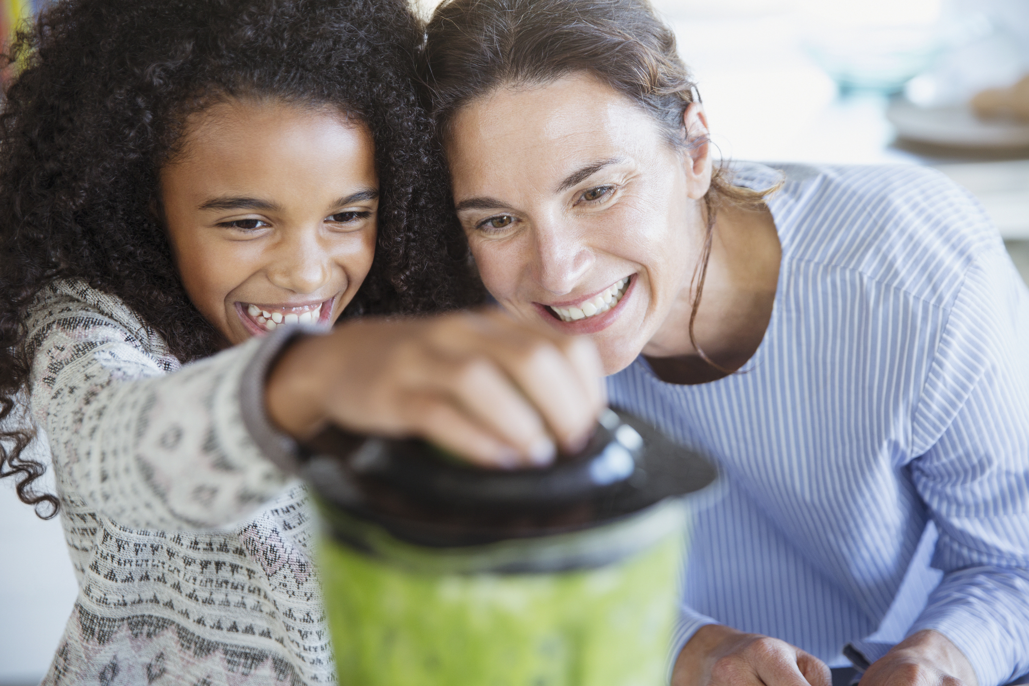 mom and daughter make smoothie